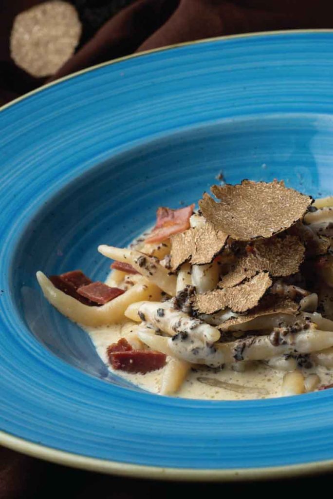 Homemade Istrian pasta with truffle cream sauce and prosciutto, served at Konoba Kod Luce in Vrsar.